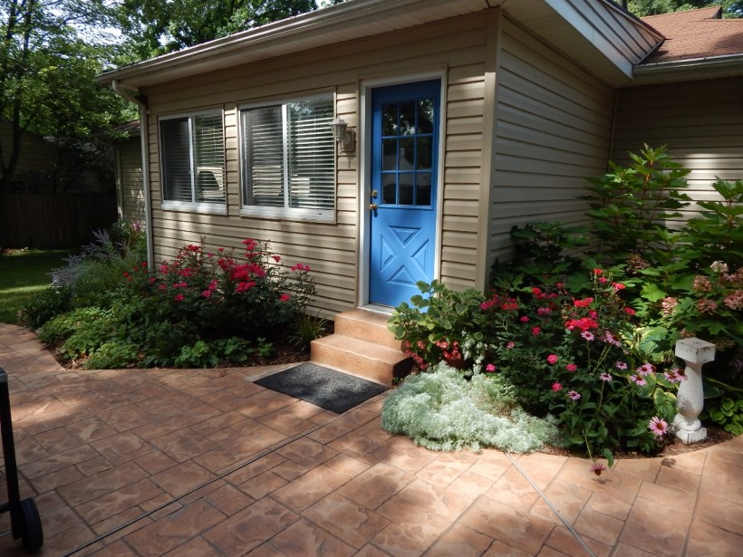 My "vision" is to wrap gardens around the house. The blue door is the entry to the den, which faces east.